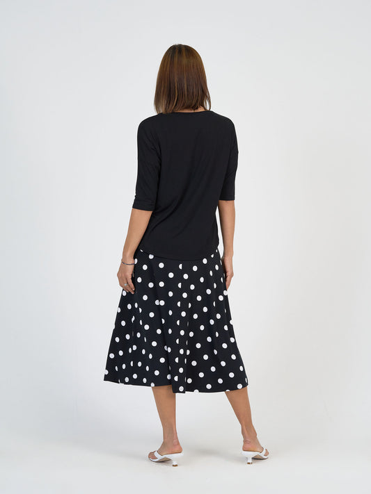 Lou Lou Australia Camila 3/4 Sleeve Bamboo Top in black, paired with a black skirt featuring white polka dots.