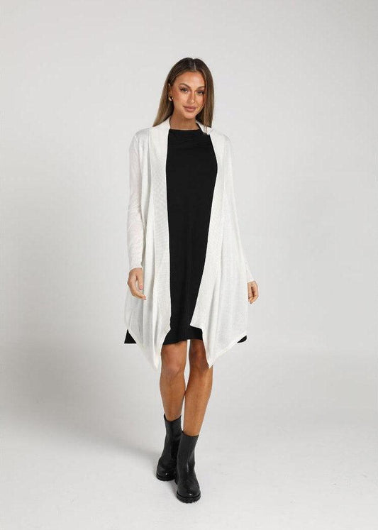 Katie Shannon wearing a white bamboo duster jacket over a black midi dress paired with black boots
