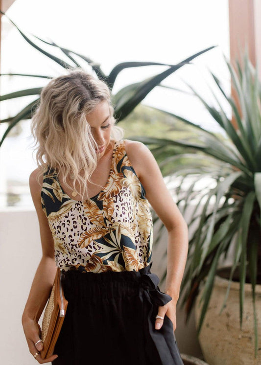 Lou Lou Australia Iris Silk Sleeveless Camisole in a light color, paired with black high-waisted pants.