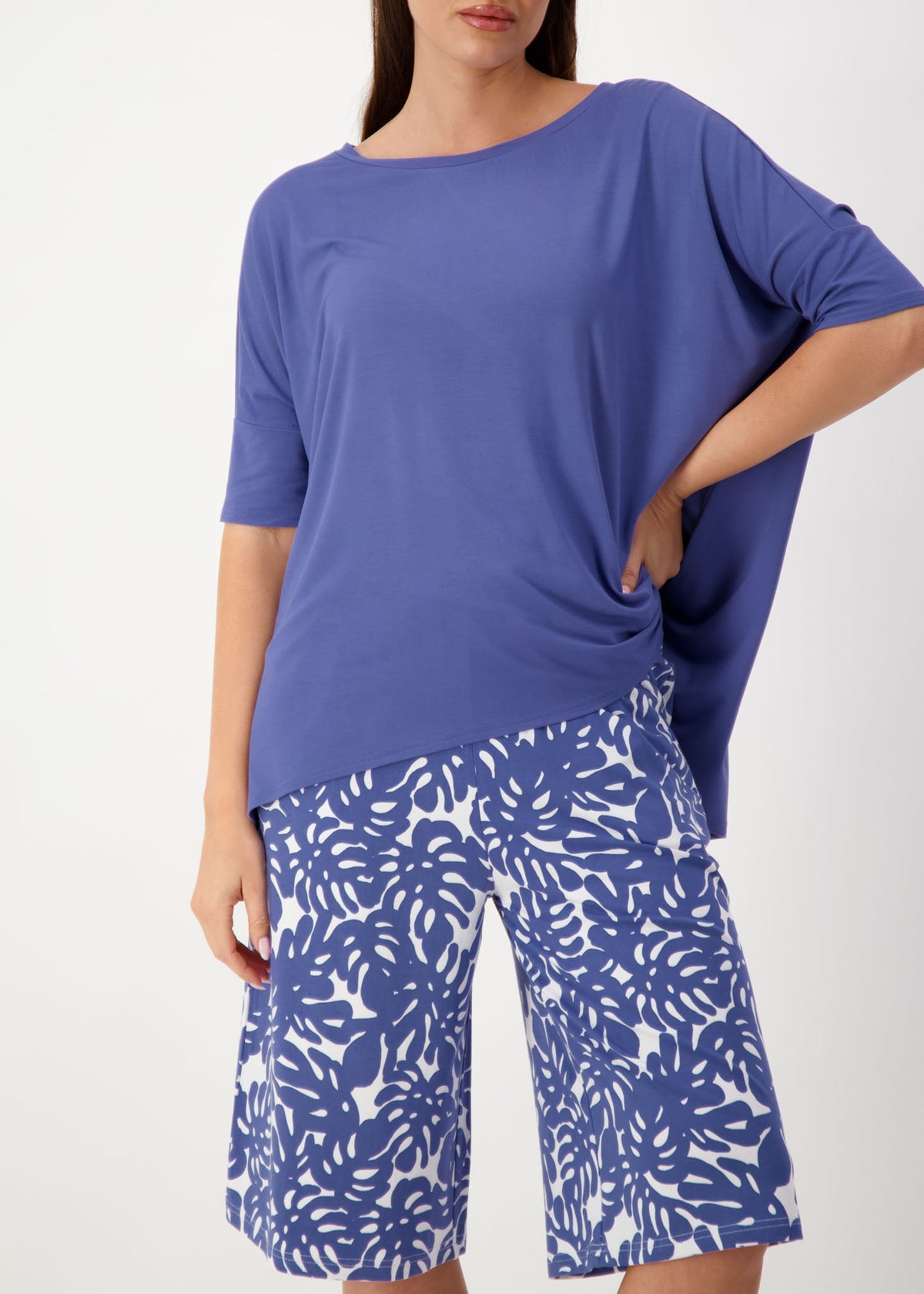 Lou Lou Australia Gina Oversized Slouch Bamboo T-Shirt in Marlin Blue with blue-and-white, leaf-patterned shorts.