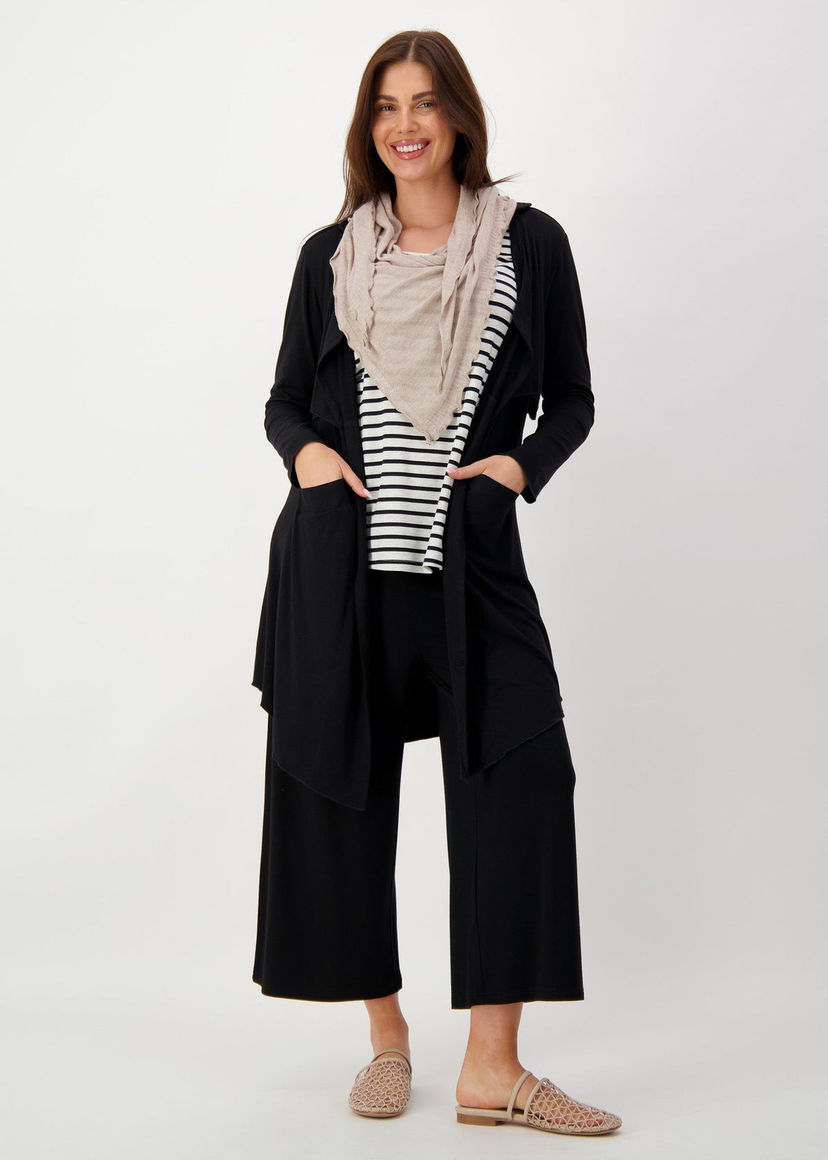A woman confidently smiling while wearing a linen bamboo scarf over a striped top and a black pants (Product image)