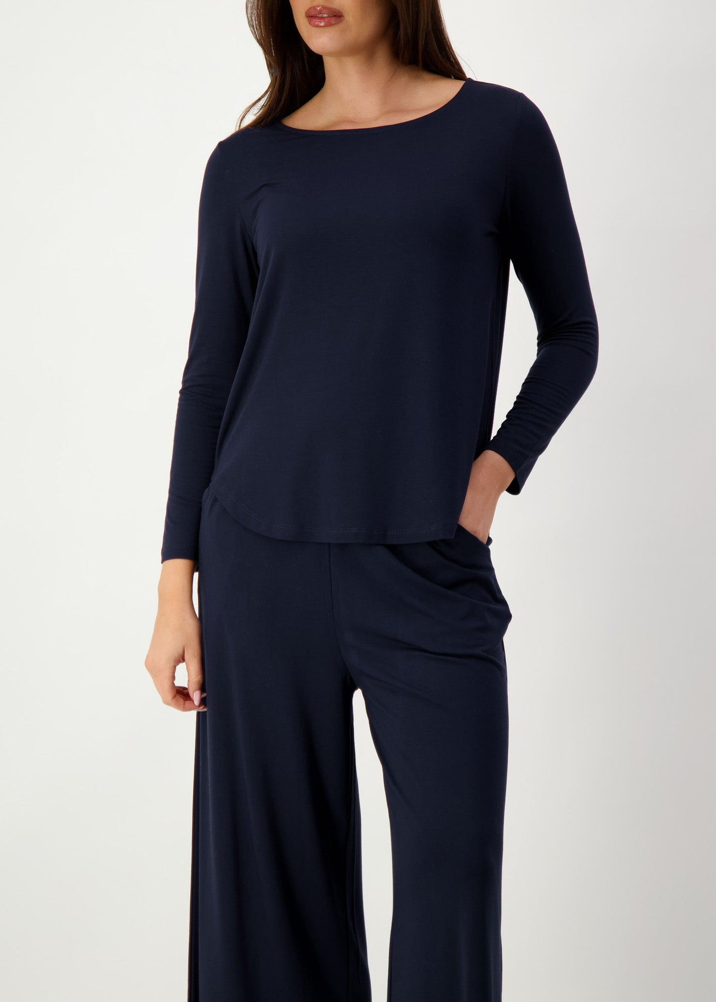 A body shot of a woman wearing 2 piece set of a navy blue long sleeve top and pants (Featured image)