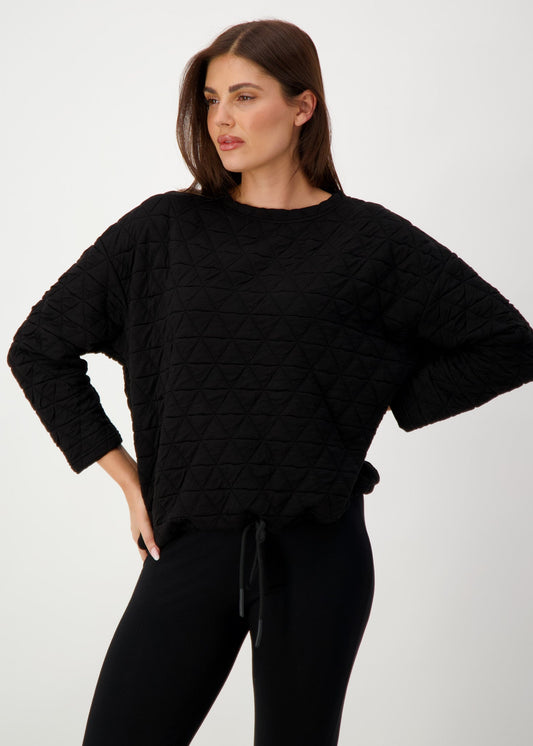 Lou Lou Australia Sacha Oversized Quilted Bamboo Sweater in black, shown with black pants.