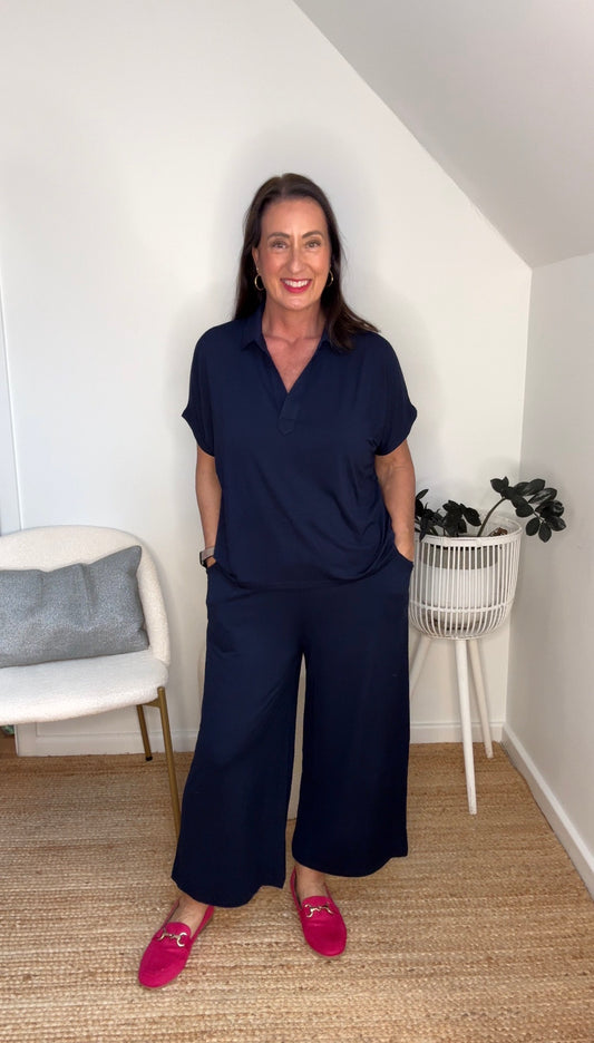 @salt.water.nomad wearing Lou Lou Australia navy bamboo polo top and culotte pants