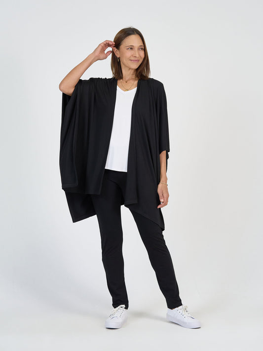 Lou Lou Australia Supreme Bamboo Travel Wrap in black, made from bamboo, shown over a white top and black leggings.