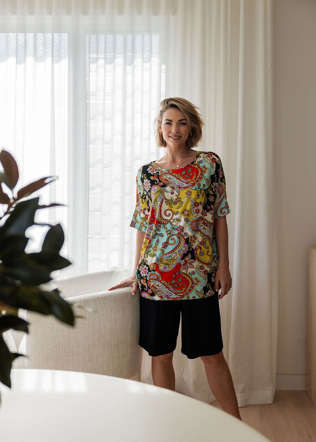 Lou Lou Australia Gina Oversized Slouch Bamboo T-Shirt in vibrant Noosa Pucci Print with black knee-length shorts.