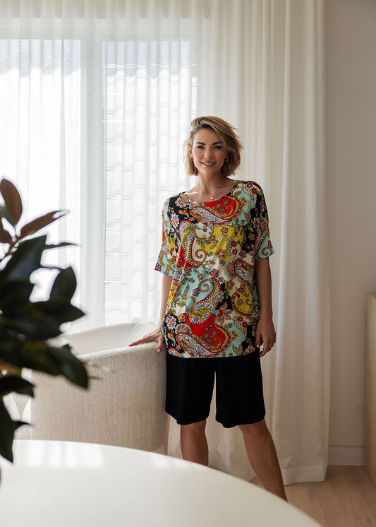 Lou Lou Australia Gina Oversized Slouch Bamboo T-Shirt in vibrant Noosa Pucci Print with black knee-length shorts.