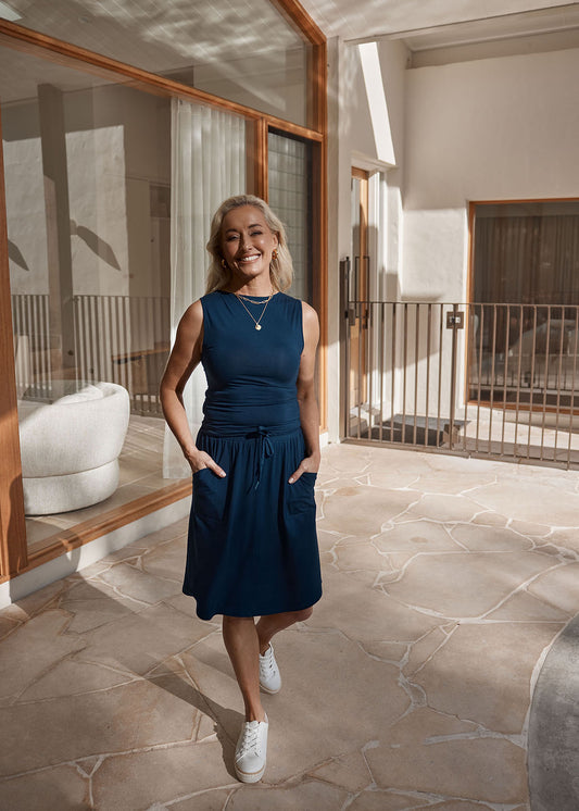 Lou Lou Australia Lee Bamboo Skirt with Pockets in Navy, made from bamboo, shown with a sleeveless navy blue top.