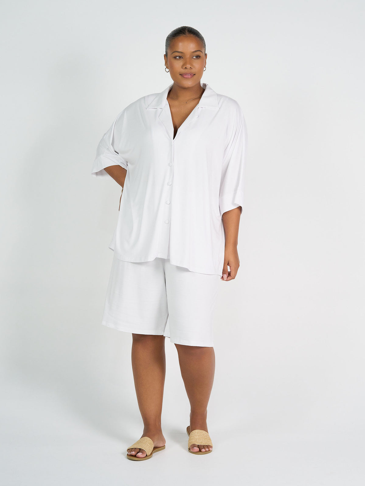 Lou Lou Australia The Cruise Set in white bamboo features a loose-fitting button-up shirt and matching shorts.