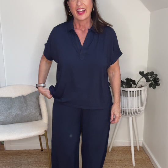 @salt.water.nomad wearing Lou Lou Australia navy bamboo polo top and culotte pants